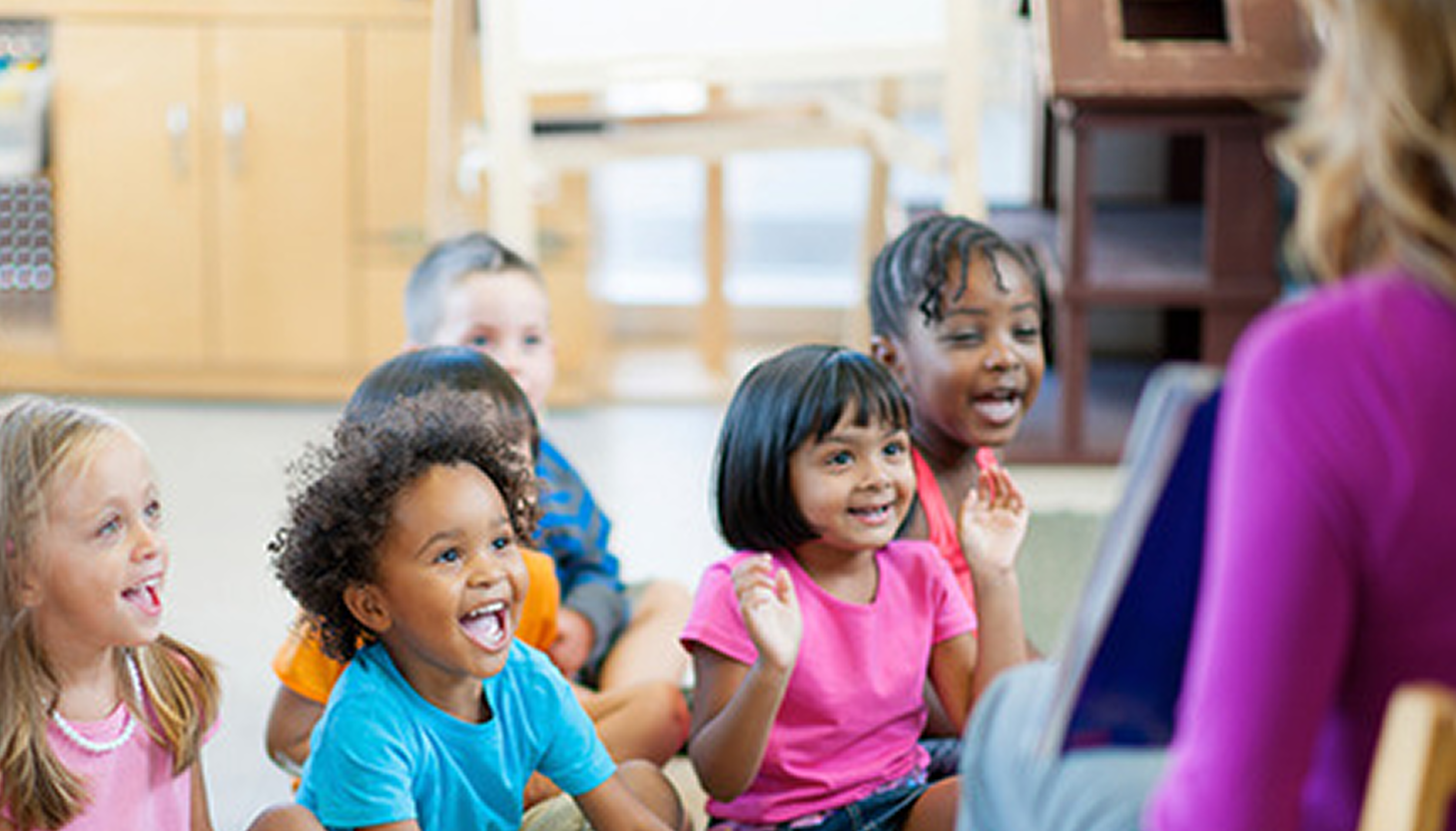 Kids sitting in library listening to a story